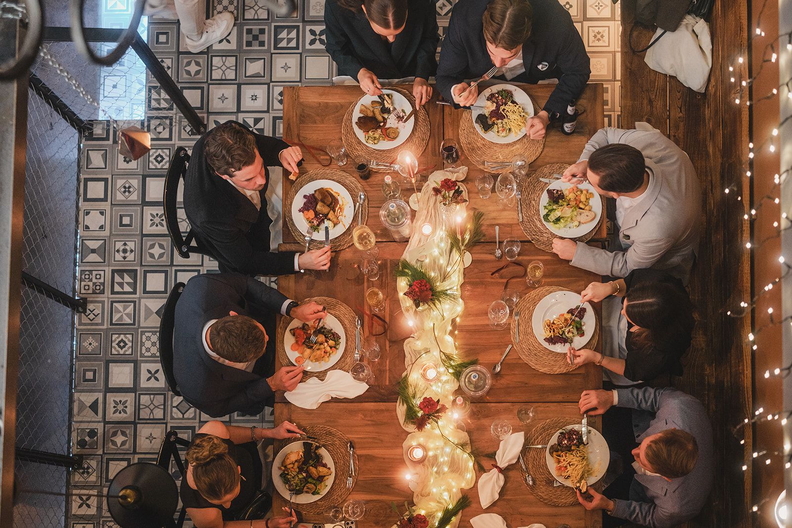 Hochzeitsgesellschaft beim Dinner an einer langen Holztafel im Eventloft Essen